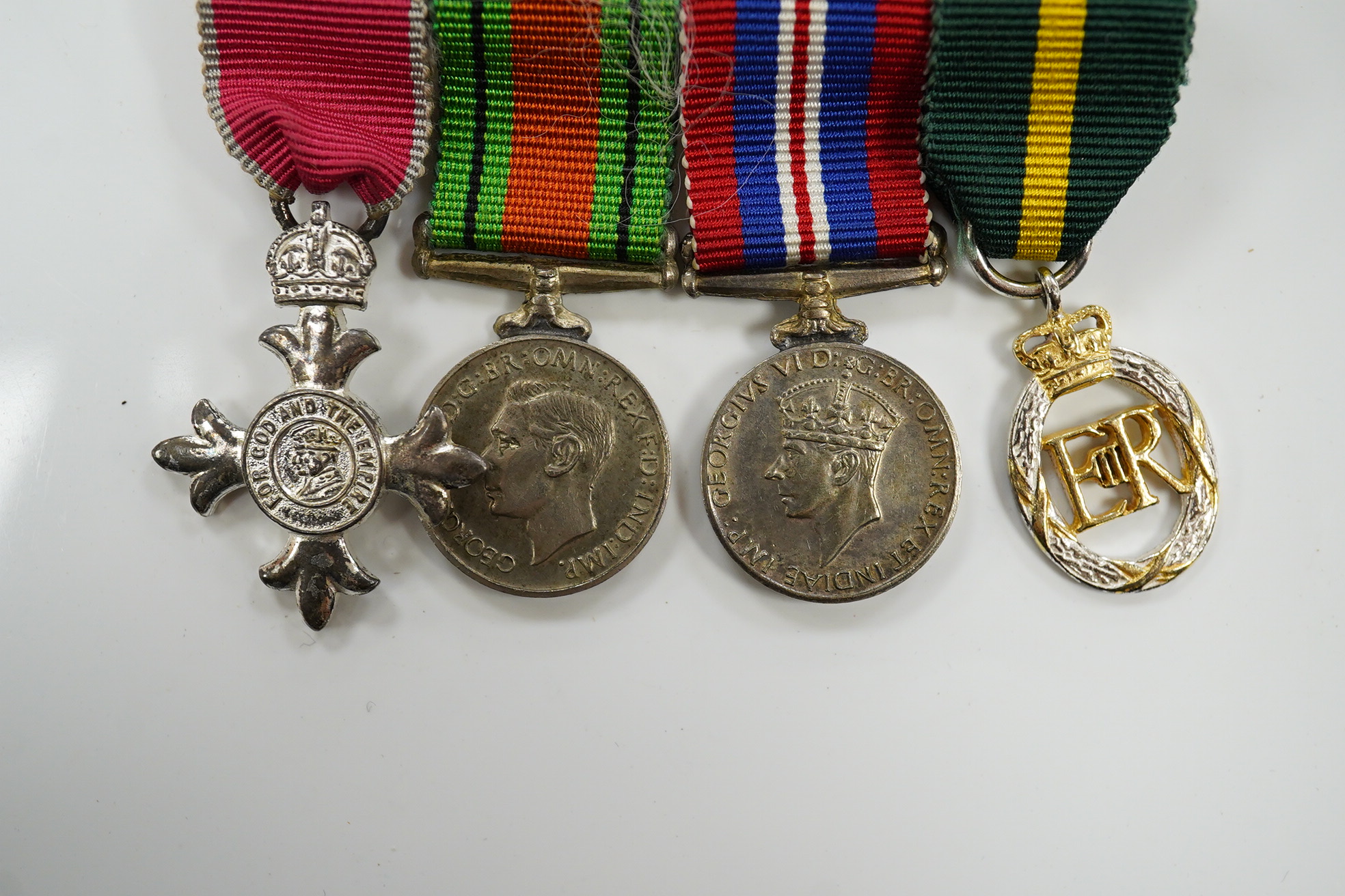 A group of 4 medals including MBE in display case